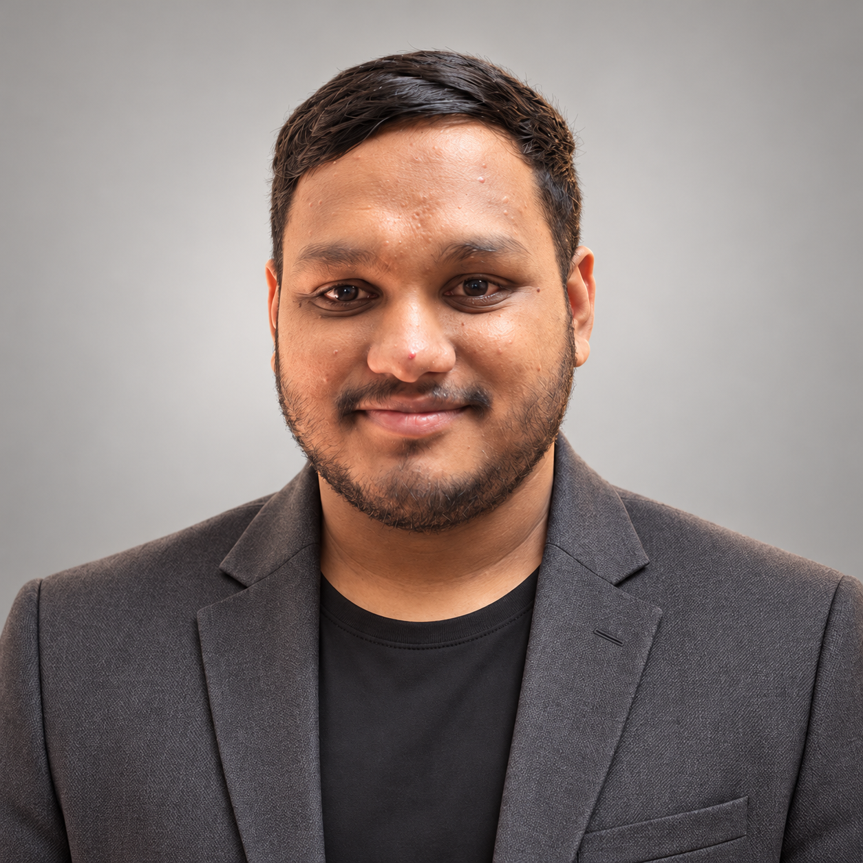 Chest-up professional portrait of Aniket Das on a light studio background